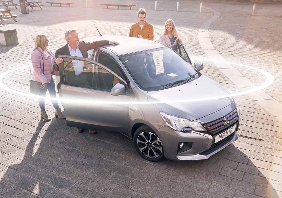 Family around Mitsubishi Mirage