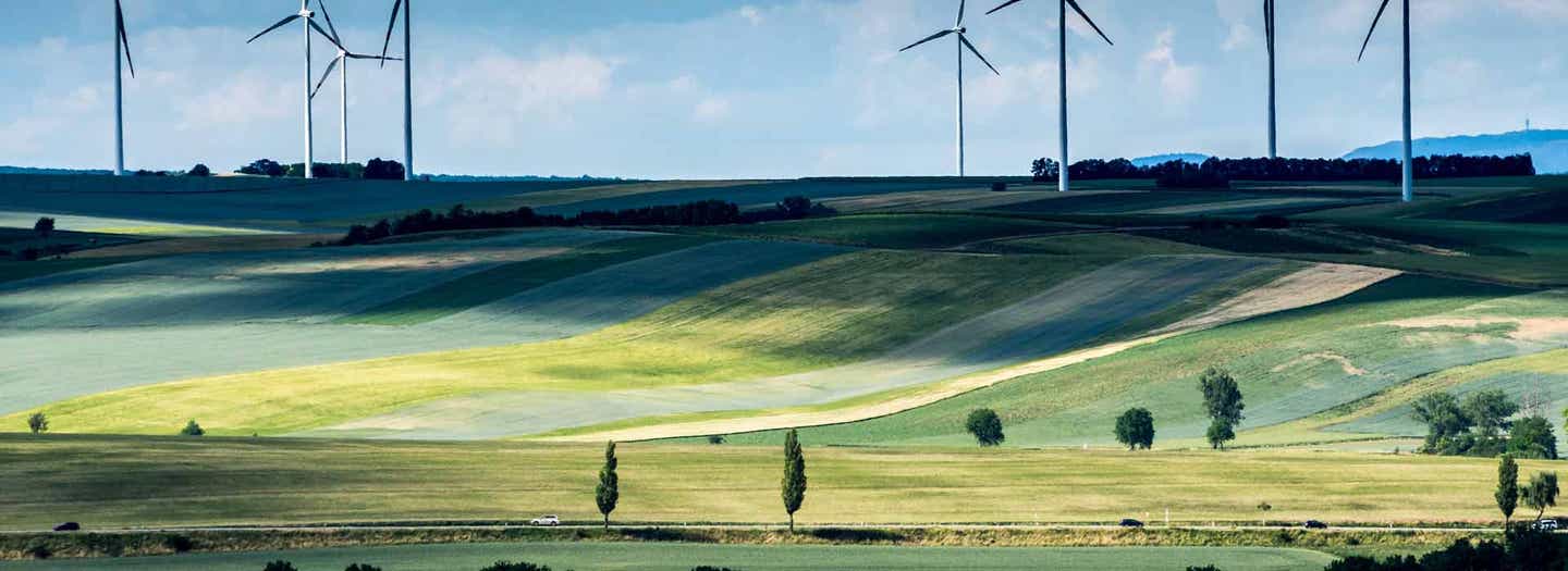 PHEV driving next to windmill